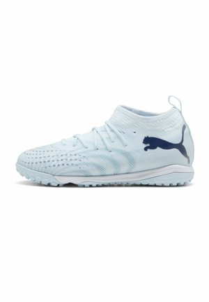 Chaussure de football Puma bleu clair avec lacets, semelle texturée pour gazon synthétique, col montant mi-hauteur à la cheville et logo Puma bleu foncé sur le côté.