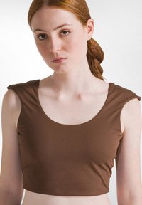 Bruine, aansluitende crop top gemaakt van een gladde, rekbare stof met een brede ronde hals en korte mouwen, met gather-accenten op de schouders.