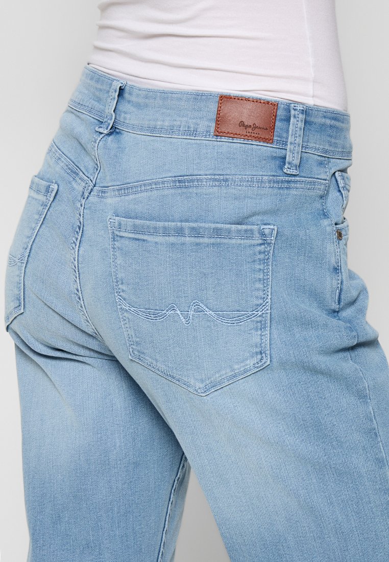 Hellblaue Denim-Jeans mit einem braunen Lederpatch mit Logo, zwei Gesäßtaschen mit dekorativer Naht und einer körpernahen Schnittführung.