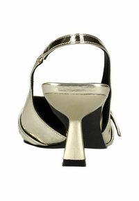 Sandale à talons en or métallique avec un dos ouvert, présentant un design épuré, une sangle texturée et un talon bloc robuste. Doublure intérieure noire.