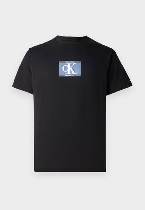 T-shirt nera a maniche corte con un logo rettangolare blu sul petto con la scritta "Calvin Klein cK New York City."