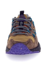 Sneaker in suede marrone con una tomaia gialla testurizzata, dettagli viola e teal, lacci grigi e una suola a motivo viola e nera.