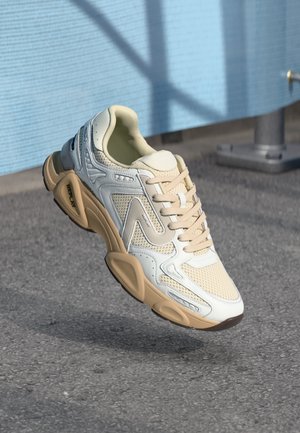 Lichte sneaker met een crème en beige mesh bovenzijde met gestructureerde accenten, ronde vorm en een dikke beige zool.