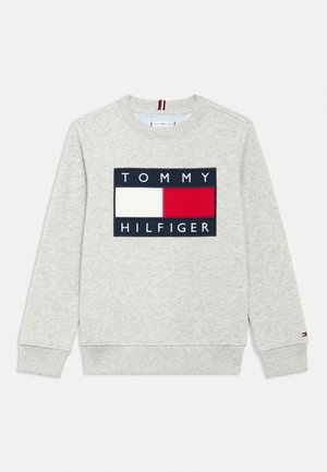 Sweatshirt gris clair à manches longues avec col rond, arborant un grand logo rectangulaire rouge, blanc et bleu marine de Tommy Hilfiger sur la poitrine.