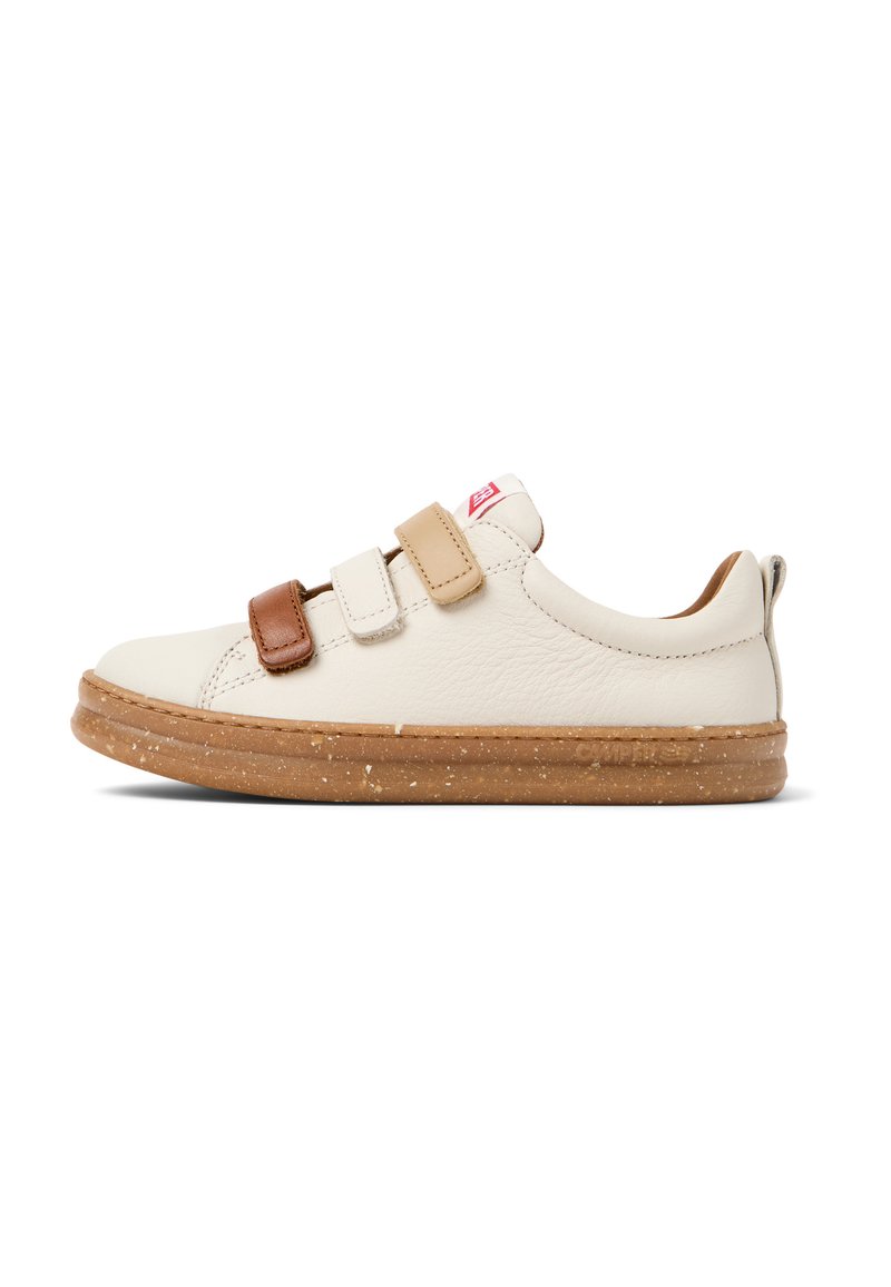 Chaussure en cuir crème avec deux bandes Velcro ajustables en beige clair et marron, semelle en caoutchouc à motif tacheté, design à bout arrondi.