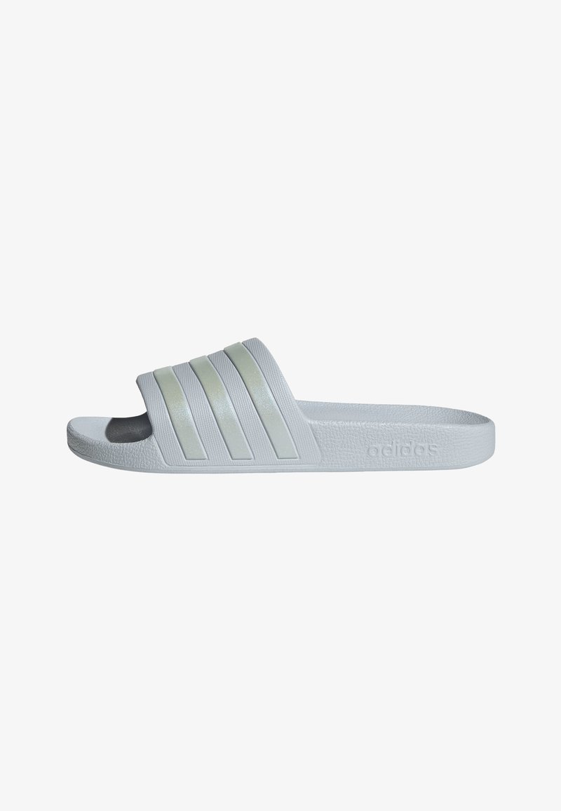 Sandale blanche Adidas à glissière avec trois sangles texturées et logo embossé sur le côté, conçue pour un usage décontracté.