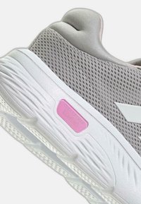 Baskets de sport gris clair avec une tige en mesh respirant, semelle texturée blanche et un accent rose "Cloudfoam Comfort" près du talon.