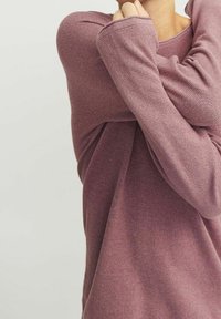 Langärmeliges Oberteil in einem gedämpften Mauve-Ton mit strukturierter Strickoptik. Die Ärmel sind leicht locker, mit rundem Ausschnitt und legerer Passform.