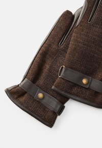 Luvas de lã castanhas com detalhes em pele, apresentando uma superfície texturizada, botões decorativos e um ajuste confortável ao redor dos pulsos.