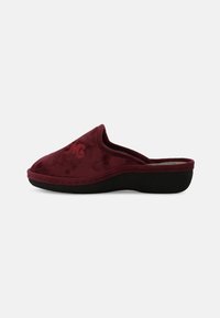 Zoccoli in suede bordeaux, con forma curva, consistenza soffice e suola in gomma nera. Presentano cuciture discrete e un logo sottile.