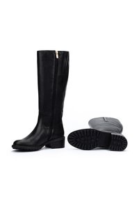 Botas de cuero negras hasta la rodilla con cierre lateral y tacón bajo. Suela texturizada con patrón de tracción, acabado liso en la parte superior.