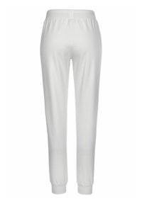 Białe spodnie sportowe o zwężanym kroju, z elastycznym pasem i ściągaczami. Wykonane z miękkiego, gładkiego materiału o jednolitej fakturze.