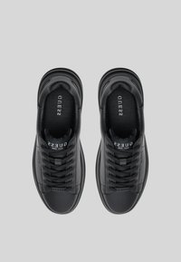Baskets en cuir noir avec une finition lisse, bout rond et lacets plats. Présente un logo sur la languette et un accent de talon texturé.