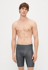 Sivé boxer spodné prádlo s mäkkým pásom, na ktorom je embosovaný nápis "BJORN BORG", vyrobené z ľahkého, elastického materiálu so hladkým povrchom.