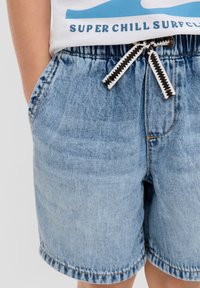 Lichtblauwe denim shorts met een elastische tailleband, zwart-witte trekkoord en zijzakken; voorzien van een rafelige zoom.