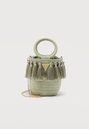 Piccola borsa rotonda intrecciata verde salvia con manico circolare, bordo con frange a nappina, tracolla a catena dorata e placchetta triangolare con logo dorato.