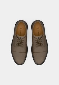 Καφέ δερμάτινα παπούτσια με λεία υφή, στρογγυλή μύτη και σχέδιο με κορδόνια. Μαύρη σόλα με λευκή ραφή και καφέ εσωτερικό. Μέγεθος 40.