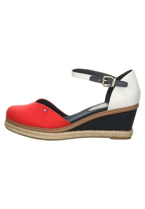 Chaussure à talon compensé avec bout arrondi rouge, semelle intermédiaire noire, contrefort blanc, bride de cheville avec boucle et garniture de semelle en corde tressée.