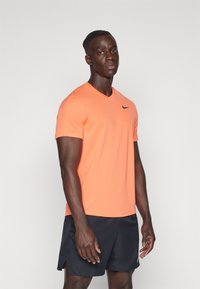 Nike Performance TOP - T-skjorte til trening - light wild mango/black
