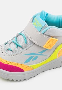 Gray synthetic shoe with multi-colored accents in pink, orange, and yellow. Features a Velcro strap, textured surface, and rounded toe.