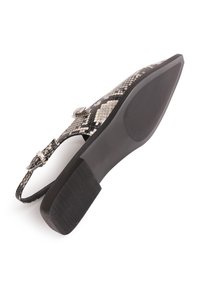 Zapato plano de estampado de serpiente en blanco y negro con puntera afilada, tira ajustable en el tobillo y suela de goma texturizada.