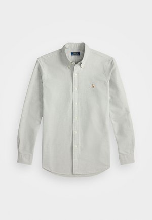 Camisa de botão cinza-claro com mangas longas, feita de tecido macio, apresentando um pequeno logótipo bordado no peito e um colarinho clássico.