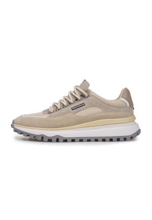 Beige Sport Schuhe aus einer Mischung von Wildleder und Netzmaterialien, mit einer dicken weißen Zwischensohle, grauer Außensohle und braunen Schnürsenkeln.