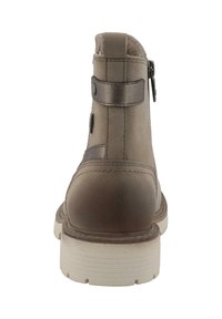 Bruine enkellaarsjes van glad leer met een ronde neus, textuur op de hak en ritsluiting. Heeft een band met metalen accenten.