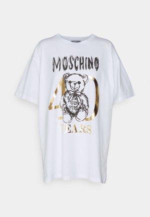 Valkoinen Moschino T-paita mustalla teddykarhuluonnoksella ja kultaisella tekstillä, jossa lukee "40 Years" ja "Moschino" edessä.