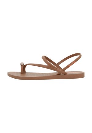 Sandalo piatto marrone con sottili cinturini incrociati e dettaglio metallico sul cinturino tra le dita, su sfondo bianco.