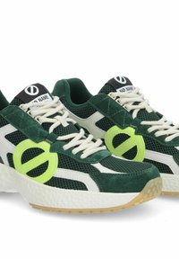 Des baskets en mesh vert et en suède présentent un accent blanc, un logo rond vert clair et une semelle intermédiaire blanche texturée avec une semelle extérieure en caoutchouc couleur gomme.