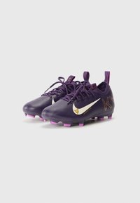 Bottes de football violettes avec une tige synthétique texturée, un Swoosh Nike doré, des crampons roses et des accents à motifs sur le côté.