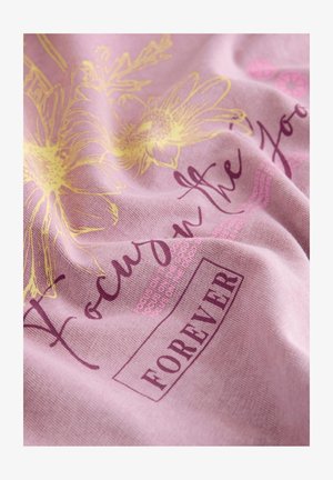 Różowa tkanina z żółtymi kwiatowymi wzorami oraz ciemnoróżowym napisem "Focus on the good" i "FOREVER" w prostokątnym ramce.