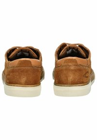 Braune Wildledersneaker mit hellbraunen Lederakzenten, runder Zehenform, strukturiertem Gummisohle und schnürlosem Design. Die Rückansicht zeigt den gepolsterten Kragen.