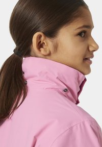 Růžová voděodolná bunda s vysokým límcem, vyznačující se patentkami a hladkou texturou. Detailní pohled na límec a oblast ramen.