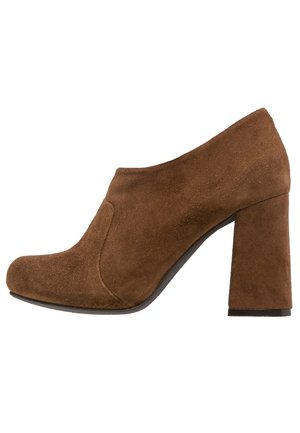 Chaussure femme en daim marron avec bout arrondi et talon bloc, style chaussures faciles à enfiler, vue de profil sur fond blanc.