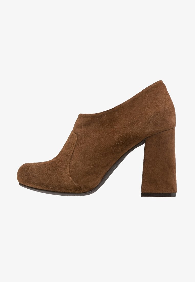 Chaussure femme en daim marron avec bout arrondi et talon bloc, style chaussures faciles à enfiler, vue de profil sur fond blanc.