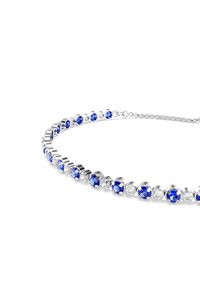 Bracciale in tono argentato con gemme rotonde blu e trasparenti alternate, montate in impostazioni metalliche circolari. Design a catena classica.