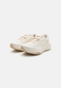 Lichte hardloopschoenen in crème met een gestructureerde mesh bovenkant, beige accenten, een gevoerde zool en een gestippeld profiel voor grip.