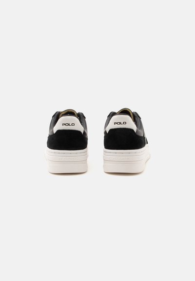 Ζευγάρι μαύρα και λευκά sneakers Polo που φαίνονται από πίσω με χοντρές λευκές σόλες και λογότυπο Polo στις ταμπελίτσες της φτέρνας.