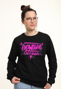 Felpa nera con grafica vivace in rosa che recita "LOS ANGELES CALIFORNIA" e elementi di design. Maniche lunghe con scollatura a girocollo.