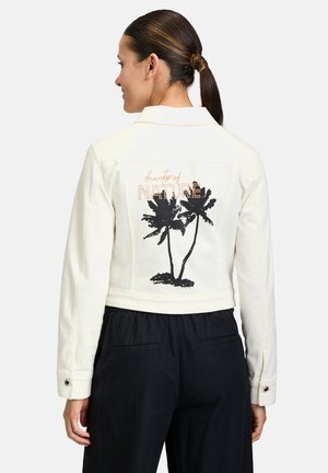 Witte denim jacket met zwarte palmboomgrafiek en de tekst "beauty of nature" in een metallic accent. Heeft een kraag en knoopmanchetten.