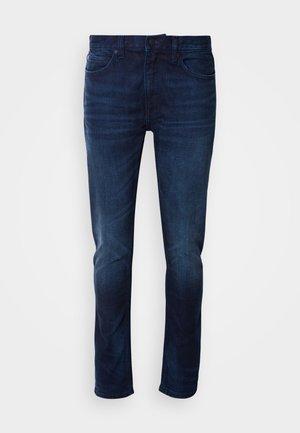 Σκούρο μπλε τζιν παντελόνι με λεία υφή, σχέδιο πέντε τσεπών και κλασική ίσια γραμμή. Κλείσιμο με μεταλλικό κουμπί και φερμουάρ.