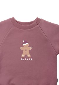 Pink sweatshirt with a round neckline and raglan sleeves. Features a gingerbread character and "FA LA LA" text in white.