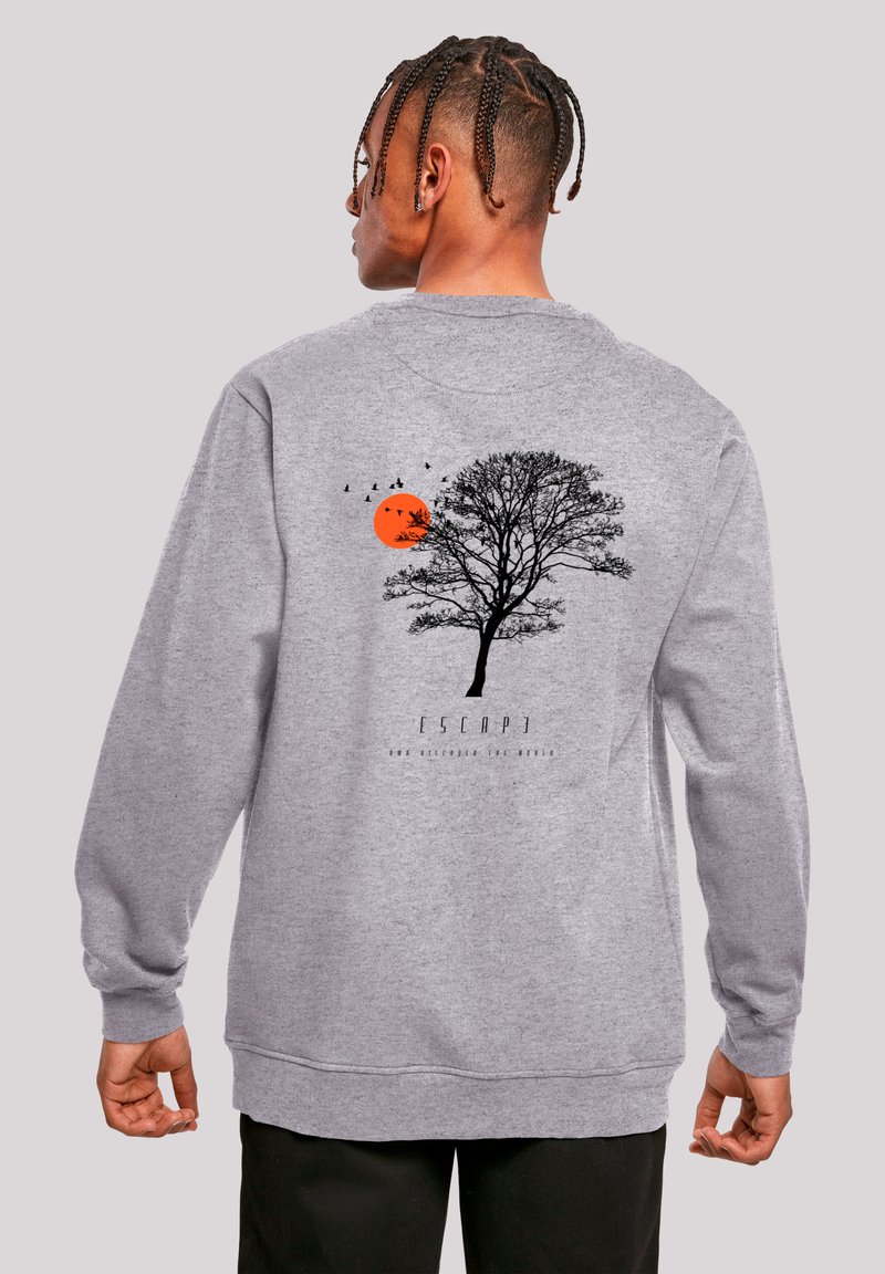 Gray sweatshirt featuring a black tree silhouette, an orange sun, and birds in flight, with the text "ESCAPE" below the design.