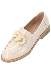 Loafer de cuero sintético color beige con un acento de crema anudado, punta en forma de almendra y un tacón bajo apilado. Textura suave con detalles de costura.