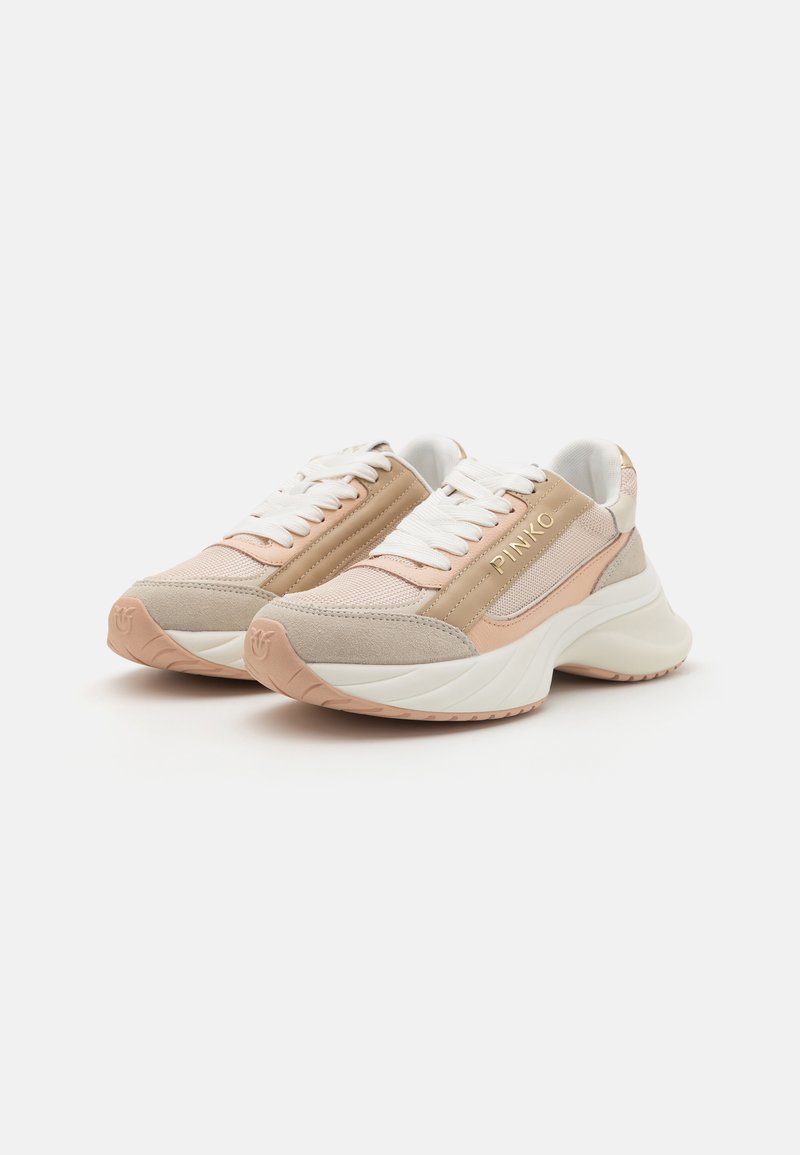 Baskets avec un mélange de textiles beige et d'accents en cuir, lacets blancs, semelle épaisse crème et détail du logo sur le côté.