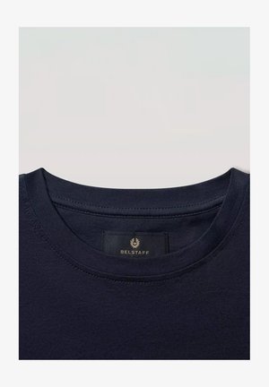 Primo piano di una t-shirt blu navy con scollo a girocollo che mostra l’etichetta del marchio Belstaff cucita all’interno del colletto.
