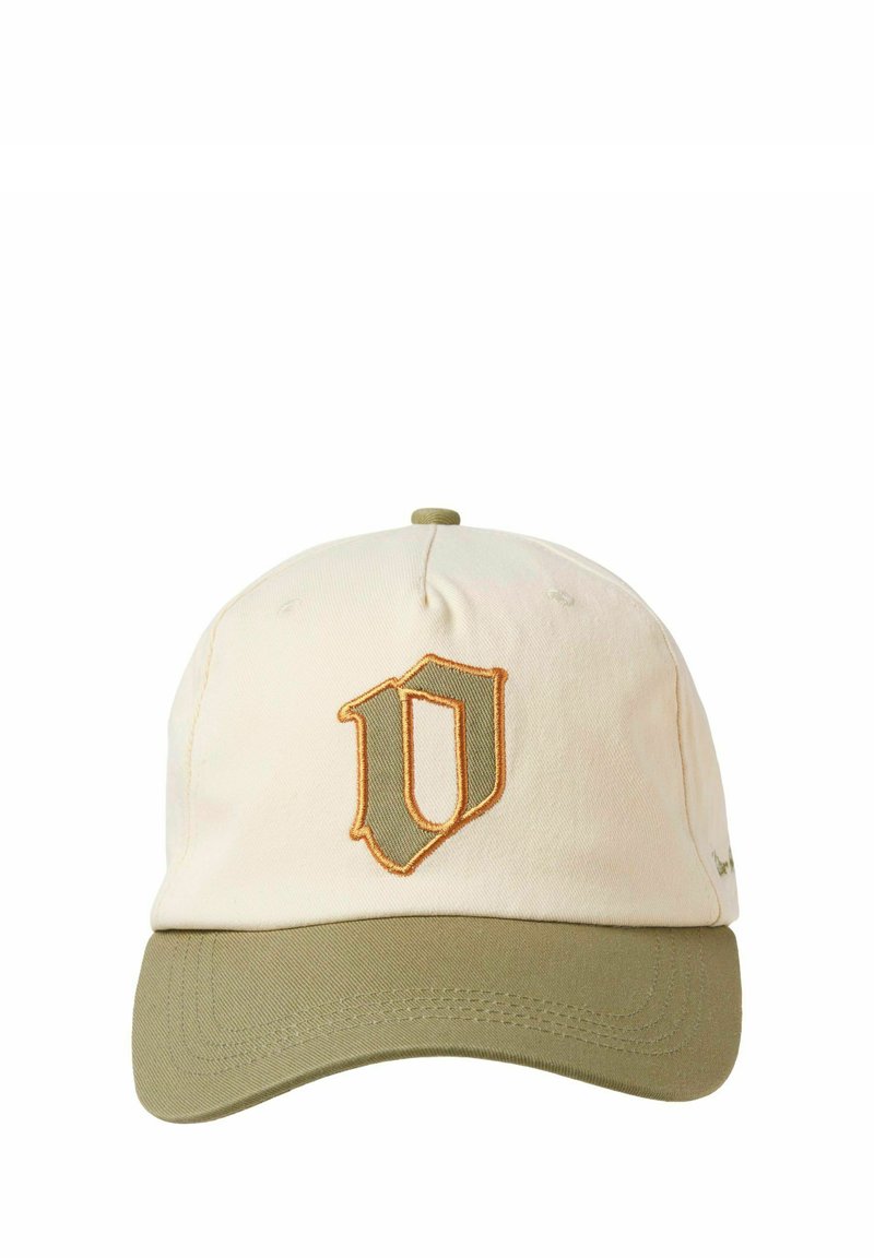 Cap with a cream cotton body and a green bill. Features an embroidered shield logo in gold and green on the front.