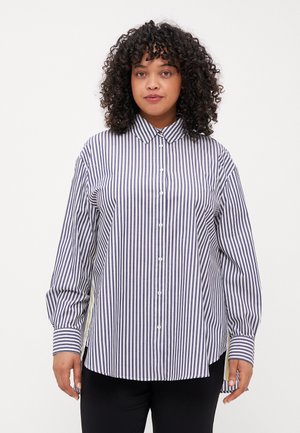 Camicia a righe blu e bianca, maniche lunghe, colletto classico e una vestibilità rilassata con orlo arrotondato. Presenta chiusura frontale con bottoni e fessure laterali.